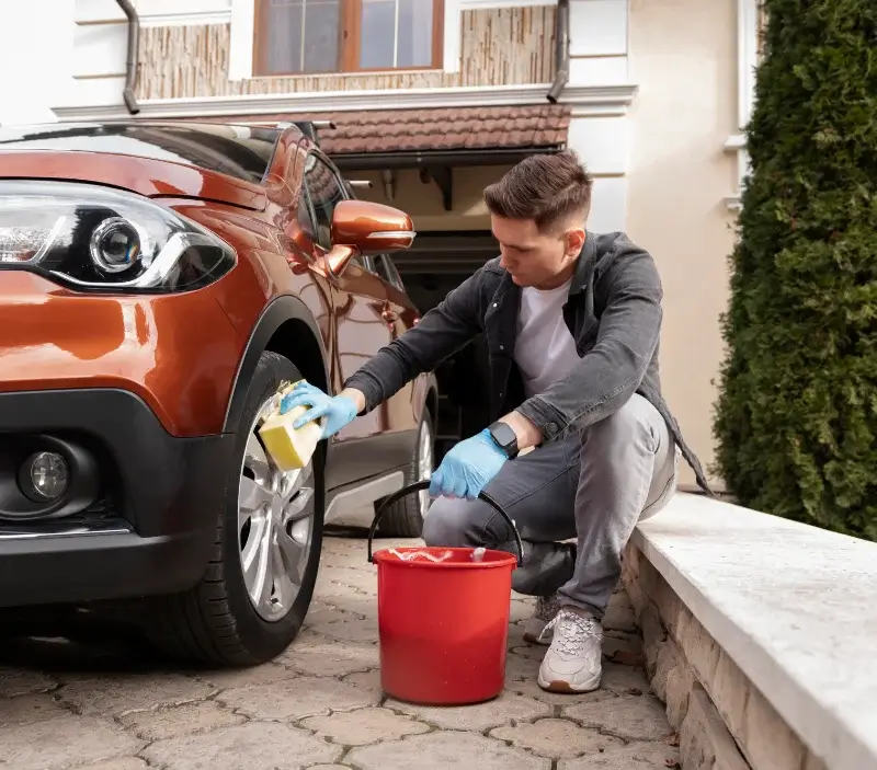 Lavage auto à domicile Faverges-de-la-Tour : professionnel intervenant sur un véhicule